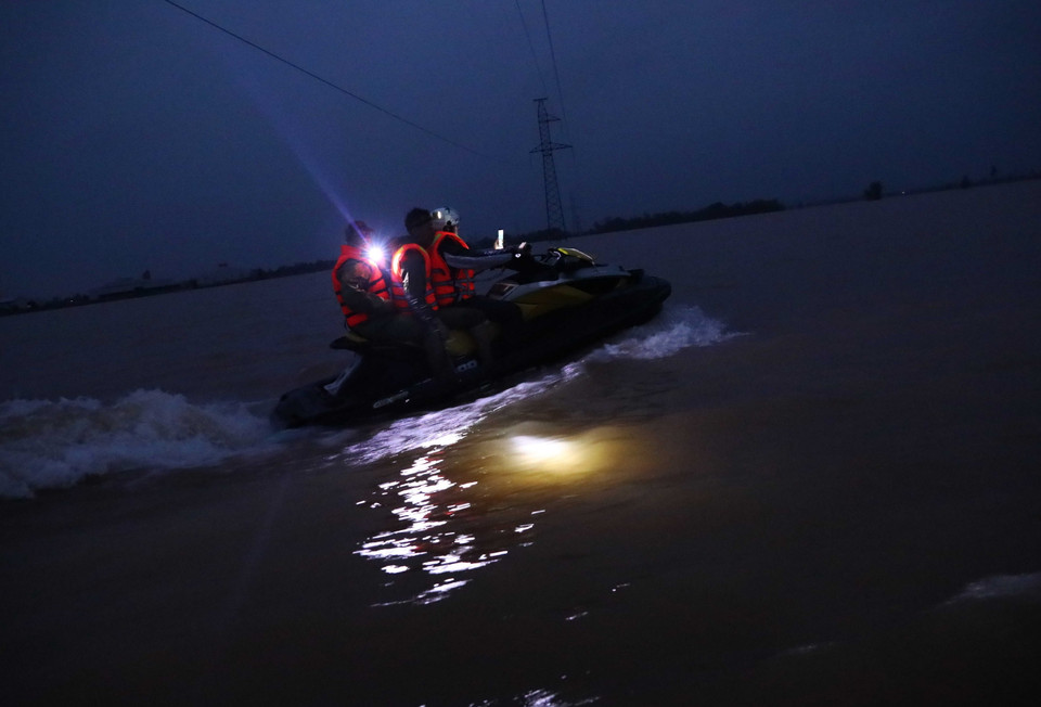 Lực lượng quân đội tỉnh Hà Tĩnh dùng ca nô di chuyển trong đêm vào cứu trợ cho người dân bị cô lập tại xã Cẩm Vĩnh, huyện Cẩm Xuyên, Hà Tĩnh (Ảnh chụp đêm 20/10/2020). (Ảnh: TTXVN)