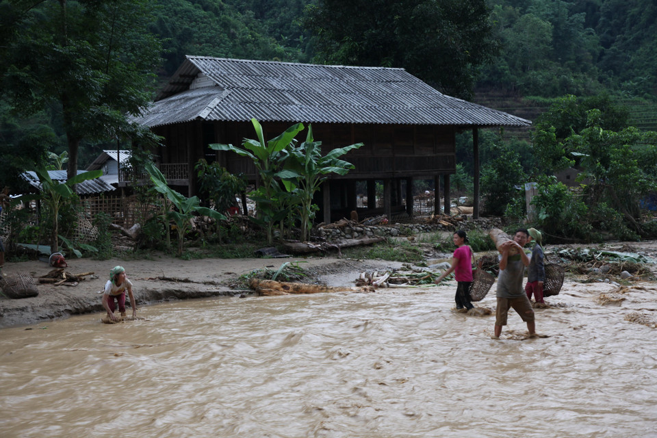 Các hộ dân sống bên suối phải thu gom vật dụng để di dời. (Ảnh: Việt Hoàng/TTXVN)