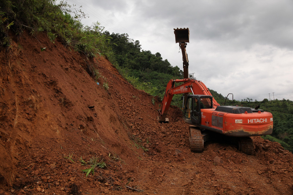 Máy móc san đất nhằm thông quốc lộ 4H bị sạt lở. (Ảnh: Việt Hoàng/TTXVN)