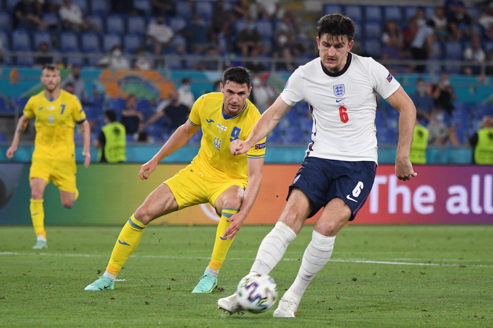 Pha tranh bóng giữa tiền đạo Ukraine Roman Yaremchuk (giữa) và hậu vệ Anh Harry Maguire (phải). (Ảnh: AFP/TTXVN)