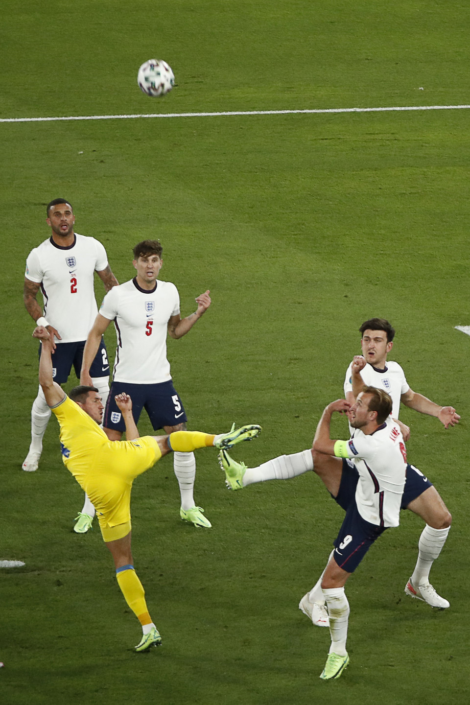 Pha tranh bóng giữa tiền đạo Anh Harry Kane (phải, phía trước) và hậu vệ Ukraine Serhiy Kryvtsov (trái). (Ảnh: AFP/TTXVN)
