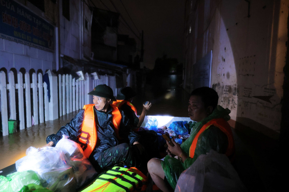 Cán bộ, chiến sỹ lữ đoàn 210 tiếp tế lương thực, thực phẩm, nước uống cho người dân phường Quang Vinh trong tối 10/9. (Ảnh: Hoàng Hiếu/TTXVN)