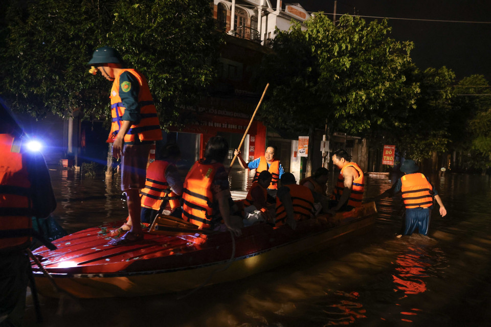 Thuyền của bộ đội mang lương thực, nước uống hỗ trợ người dân trong các phố đang bị ngập do nước lũ. (Ảnh: Hoàng Hiếu/TTXVN)