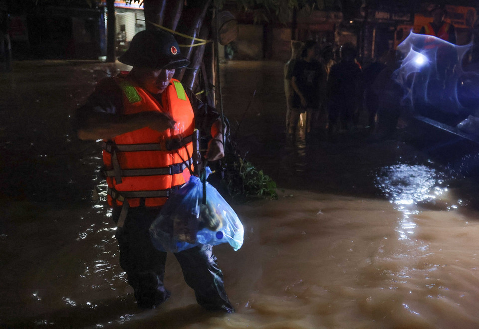 Bộ đội treo thực phẩm cứu trợ cho các hộ dân bị ngập tại phường Quang Vinh tối 10/9. (Ảnh: Hoàng Hiếu/TTXVN)