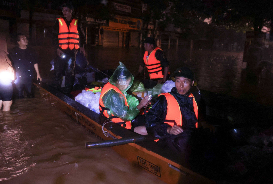 Cán bộ, chiến sỹ Lữ đoàn 210 tiếp tế lương thực, thực phẩm, nước uống cho người dân phường Quang Vinh trong tối 10/9. (Ảnh: Hoàng Hiếu/TTXVN)