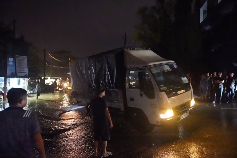 Người dân di chuyển xe tải khỏi khu vực bến đỗ xe 46 Chương Dương Độ (quận Hoàn Kiếm). (Ảnh: Phạm Tuấn Anh/TTXVN)