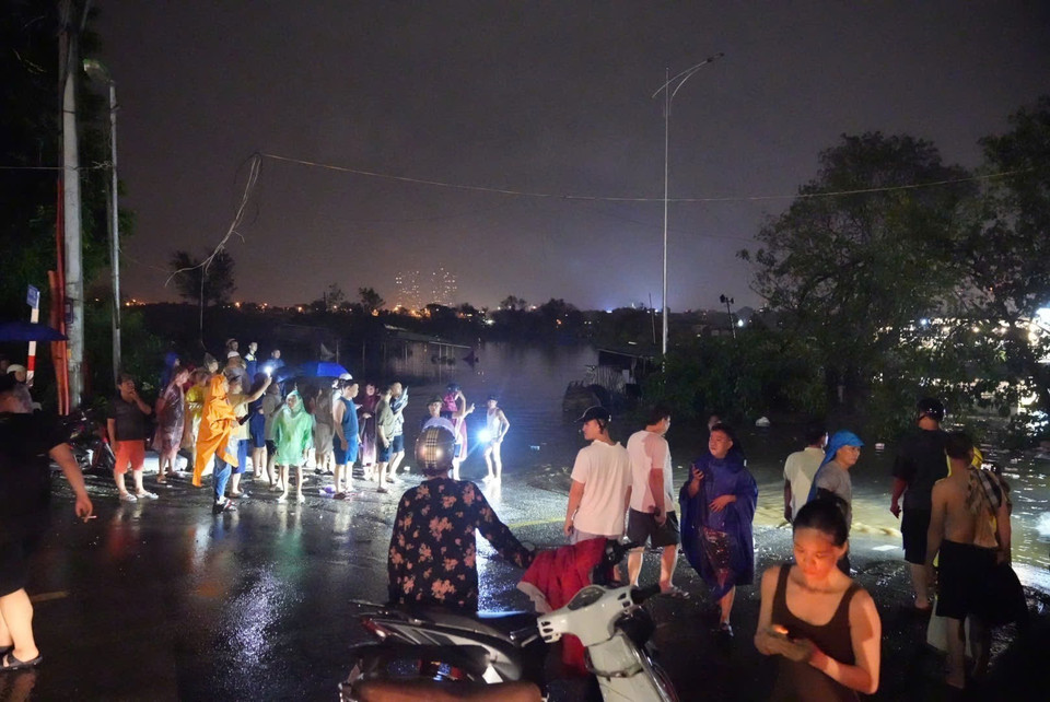 Người dân tại khu vực phố Chương Dương Độ lo lắng khi nước sông ngày càng dâng lên cao. (Ảnh: Phạm Tuấn Anh/TTXVN)