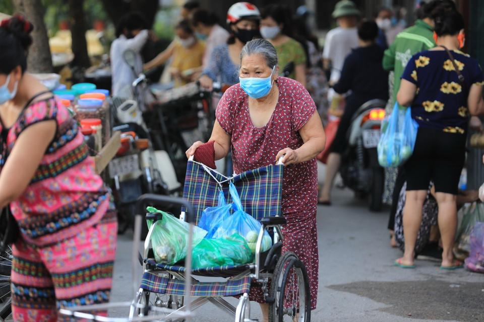 Một cụ già còn mang cả xe đẩy đi chất hàng hóa, lương thực, thực phẩm (ảnh chụp 8h sáng 19/7). (Ảnh: Thành Đạt/TTXVN)