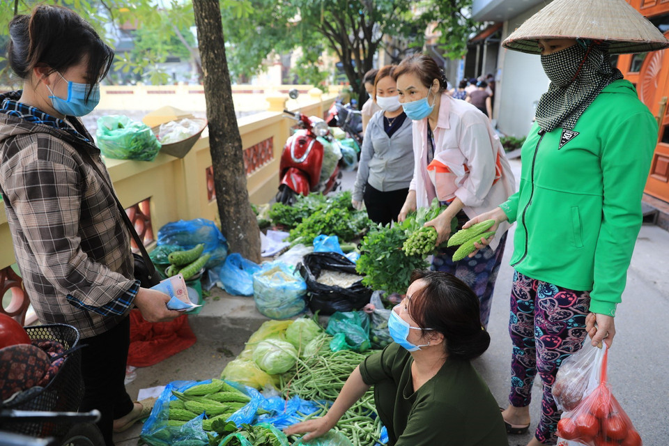 Người dân tập trung mua hàng tại một chợ cóc dân sinh theo quy định không được phép mở cửa (ảnh chụp 8h sáng 19/7). (Ảnh: Thành Đạt/TTXVN)