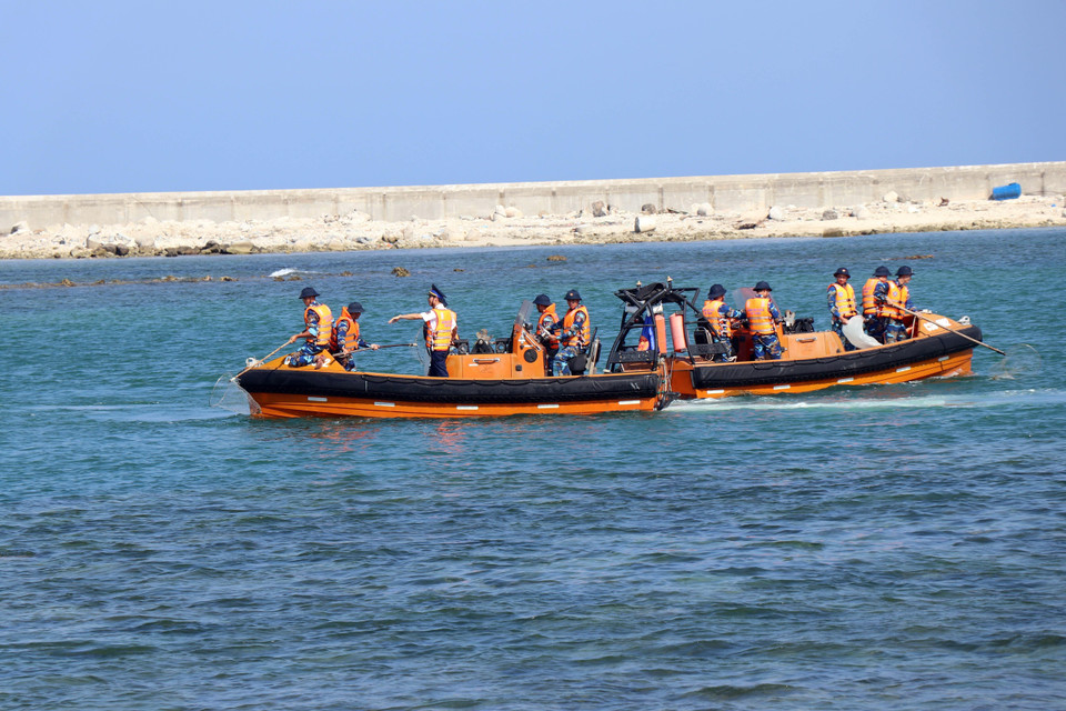 Chiến sỹ Vùng cảnh sát biển 2 phối hợp với thanh niên tình nguyện dọn vệ sinh môi trường biển tại huyện đảo Lý Sơn, Quảng Ngãi. (Ảnh: Trần Tĩnh/TTXVN)