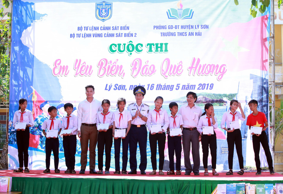 Đại diện các nhà hảo tâm và Bộ Tư lệnh Vùng Cảnh sát biển 2 trao học bổng cho học sinh nghèo xã An Hải, huyện đảo Lý Sơn, tỉnh Quảng Ngãi. (Ảnh: Trần Tĩnh/TTXVN)