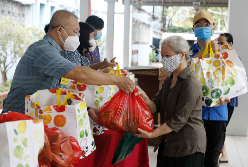 Trong ảnh: Đại diện cơ quan, đoàn thể nhà hảo tâm trao những túi quà cho hộ nghèo, gia đình chính sách ở phường Giảng Võ. (Ảnh: Trần Việt/TTXVN)