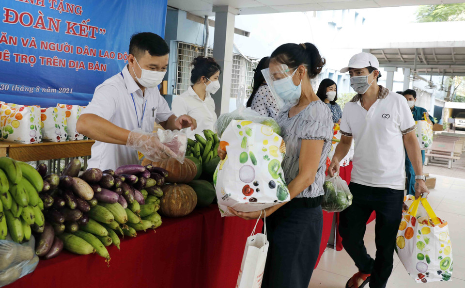 Đại diện cơ quan, đoàn thể nhà hảo tâm trao những túi quà cho hộ nghèo ở phường Giảng Võ. (Ảnh: Trần Việt/TTXVN)
