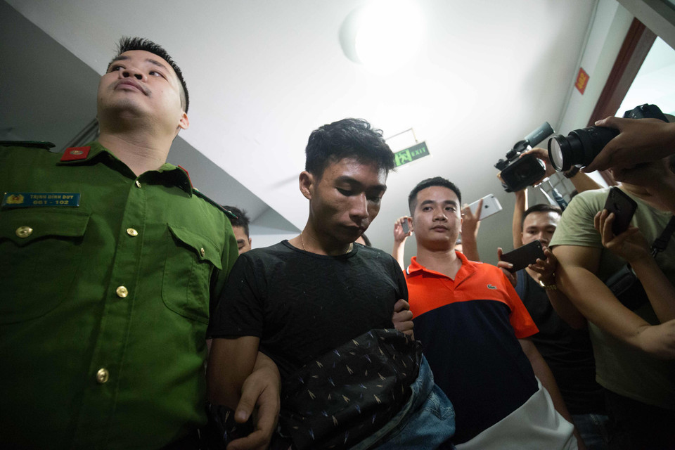 Đối tượng Giáp được lực lượng chức năng áp giải đến phòng lấy lời khai. (Ảnh: PV/Vietnam+)