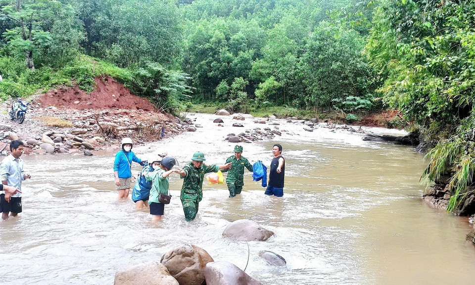 Bộ đội Biên phòng trên tuyến biên giới Quảng Bình hỗ trợ, hướng dẫn người dân di chuyển an toàn qua các điểm giao thông bị hư hỏng sau bão số 4. (Ảnh: TTXVN phát)