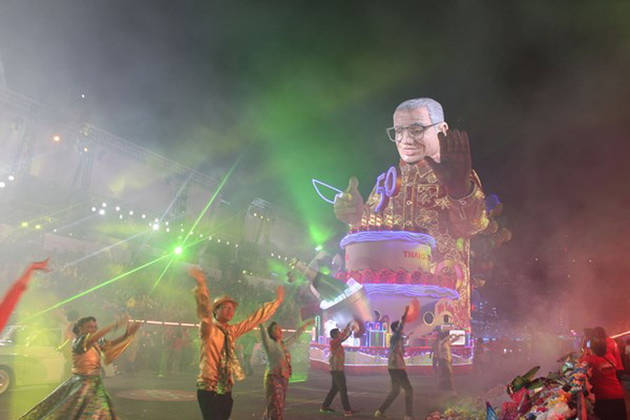 Đoàn diễu hành mang theo hình ảnh của nhà lãnh đạo Lý Quang Diệu với mong muốn ông mau bình phục và cùng chứng kiến đất nước đổi thay sau 50 năm xây dựng và phát triển. (Ảnh: Việt Hải-Mỹ Bình-Văn Hải/Vietnam+) 