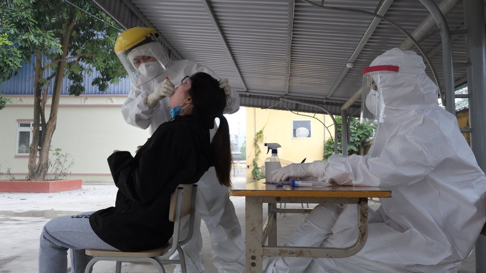 Nhân viên y tế lấy mẫu người có tiếp xúc gần. (Ảnh: Phạm Hùng/TTXVN phát)