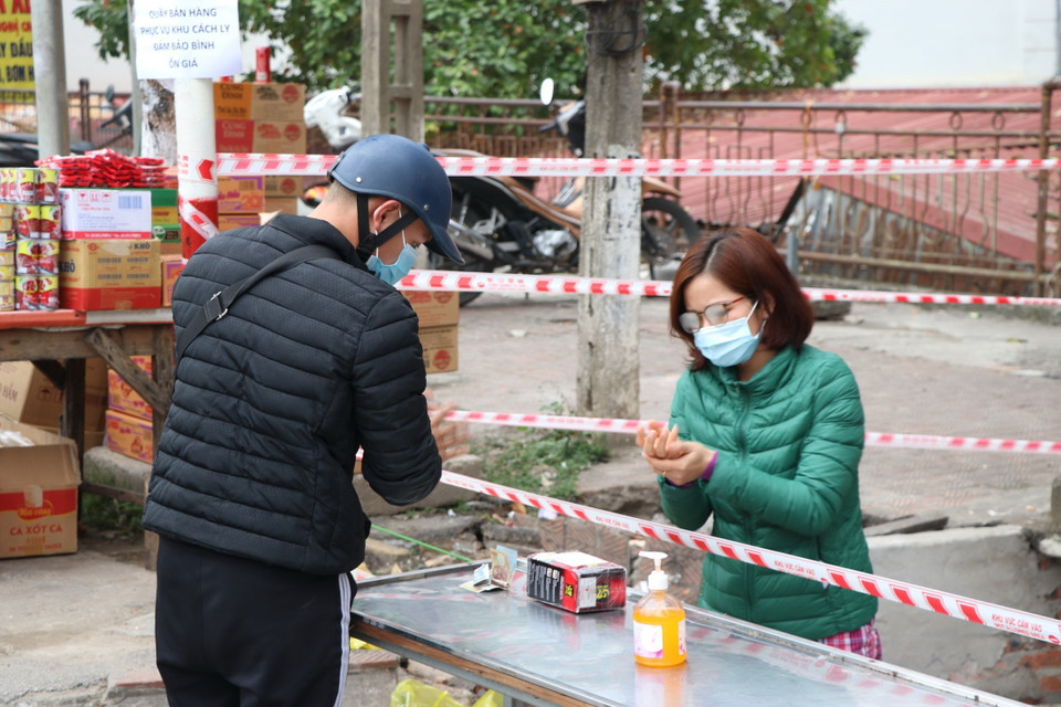 Tại thành phố Hòa Bình đã tiến hành phong tỏa khu vực xác định của F0; khẩn trương đưa F1 vào cách ly. Trong ảnh: Người dân tại khu vực cách ly khử khuẩn khi nhận đồ tiếp tế. (Ảnh: Thanh Hải/TTXVN)