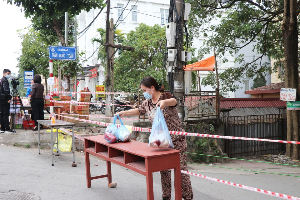Người dân khu vực cách ly nhận đồ tiếp tế bên ngoài. (Ảnh: Thanh Hải/TTXVN)