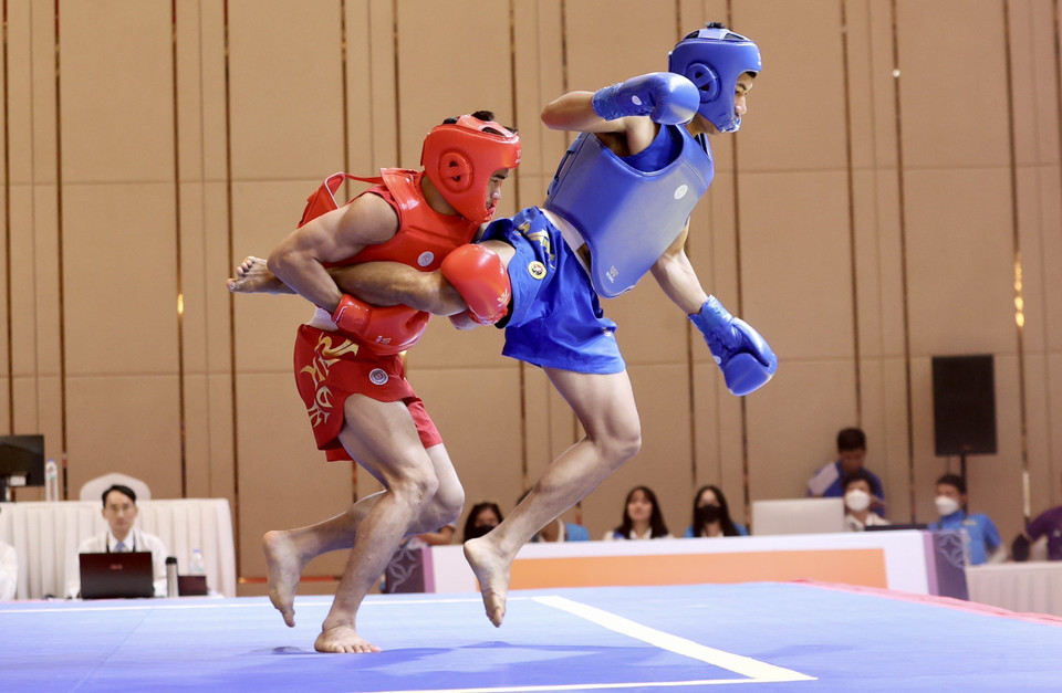 Vận động viên Đinh Văn Bí (giáp đỏ, Việt Nam) ở nội dung tán thủ hạng 70kg nam giành chiến thắng trước vận động viên Chhuon Bunthai (Campuchia, giáp xanh). (Ảnh: Hoàng Linh/TTXVN)