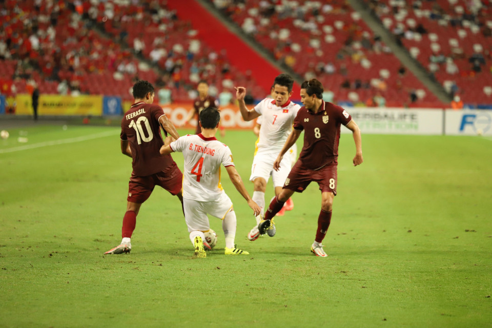 Trung vệ Bùi Tiến Dũng (4) cố gắng ngăn cản pha triển khai bóng của cầu thủ đội Thái Lan. (Ảnh: Thế Vũ/TTXVN)