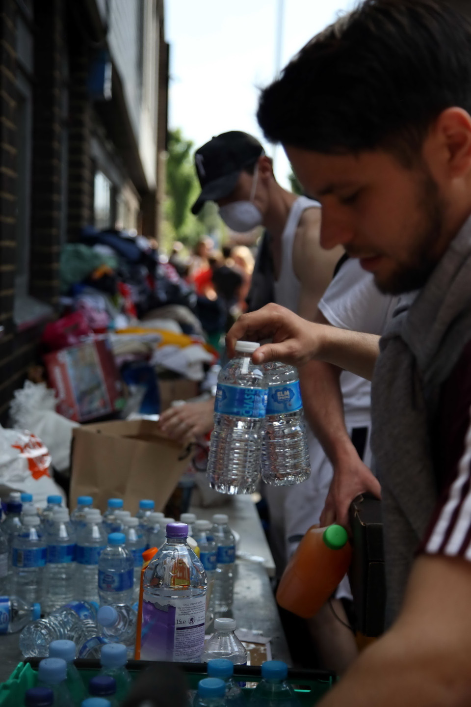 Nước uống và quần áo được xếp gọn mang đi để tiếp tế cho các nạn nhân. Những người có mặt tại hiện trường cũng được kịp thời cung cấp thực phẩm và nước uống. (Ảnh: Như Mai/TTXVN)