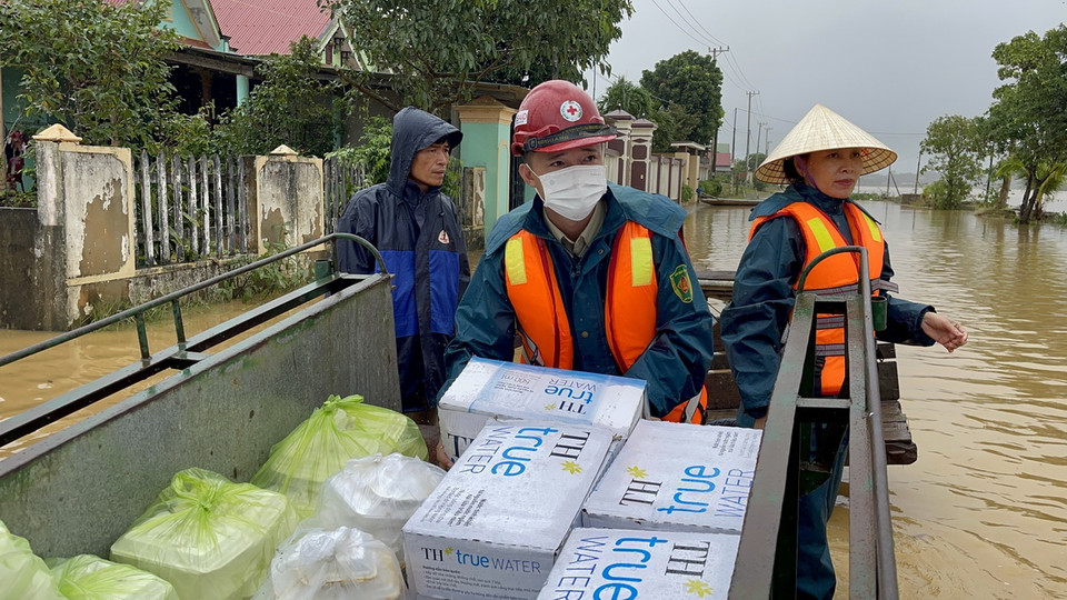 Hỗ trợ lương thực, thực phẩm cho người dân xã Vĩnh Long đang bị ngập trong nước. (Ảnh: Thanh Thủy/TTXVN)