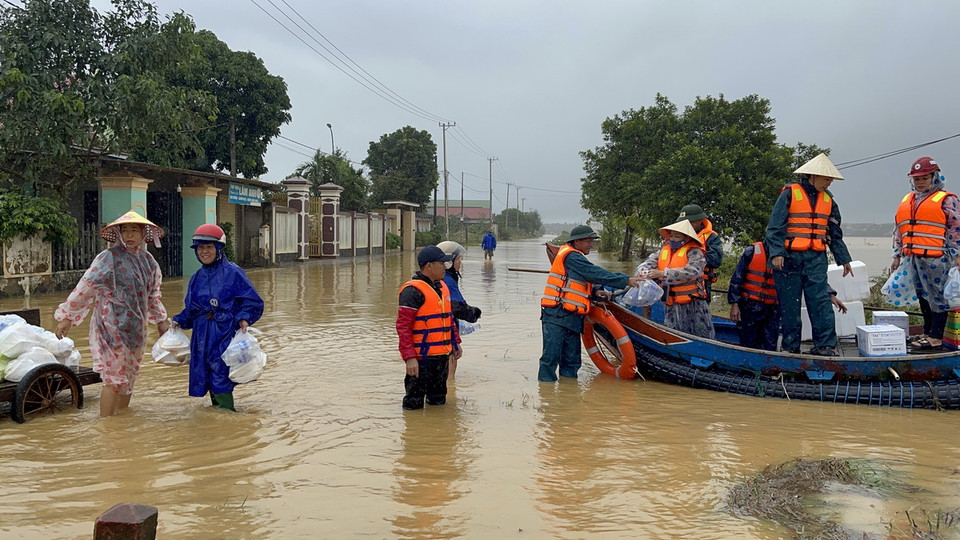 Hỗ trợ lương thực, thực phẩm cho người dân xã Vĩnh Long đang bị ngập trong nước. (Ảnh: Thanh Thủy/TTXVN)