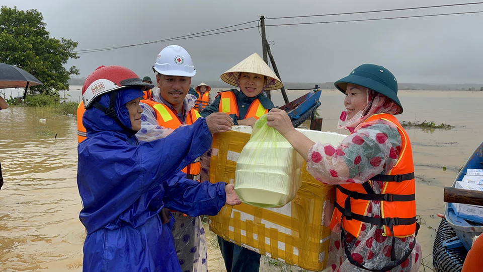Hỗ trợ lương thực, thực phẩm cho người dân xã Vĩnh Long đang bị ngập trong nước. (Ảnh: Thanh Thủy/TTXVN)