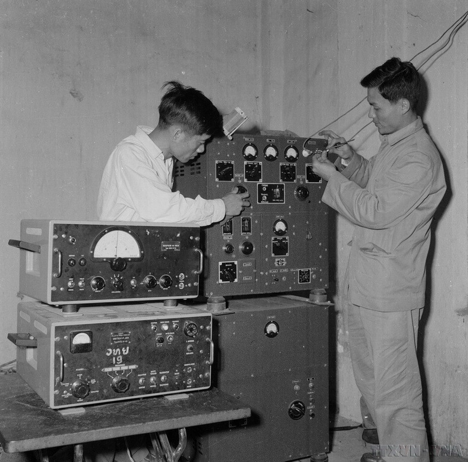 Nhân viên kỹ thuật của Thông tấn xã Việt Nam và Đài phát thanh Việt Nam lắp máy cho đài phát thanh Xiengkhuang (Lào). (Ảnh: TTXVN)