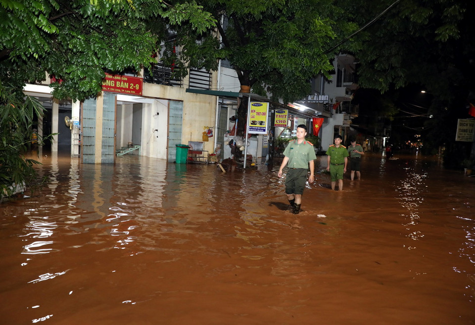 Lực lượng Công an thành phố Lạng Sơn, Công an phường Chi Lăng tuyên truyền, kêu gọi, hỗ trợ nhân dân di chuyển người và đồ đạc đến nơi an toàn. (Ảnh: Văn Đạt/TTXVN)