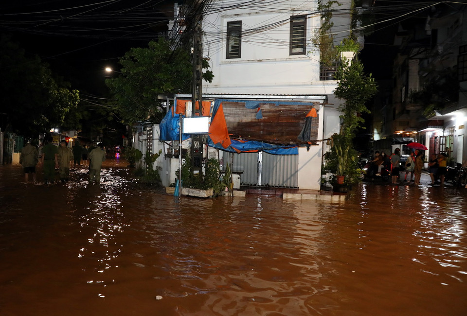 Lực lượng Công an thành phố Lạng Sơn, Công an phường Chi Lăng, tuyên truyền, kêu gọi, hỗ trợ nhân dân di chuyển người và đồ đạc đến nơi an toàn. (Ảnh: Văn Đạt/TTXVN)