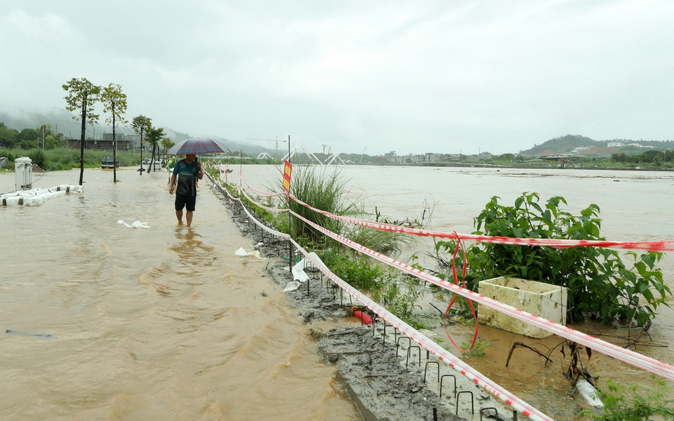 Mức nước sông Hồng dâng cao gần bằng bờ kè thành phố Lào Cai khiến người dân di chuyển khó khăn. (Ảnh: Quốc Khánh/TTXVN)