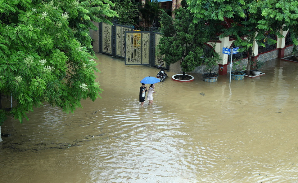 Đường Phạm Văn Xảo, phường Lào Cai, thành phố Lào Cai bị lũ tràn vào, ngập trong biển nước lúc 11g30 ngày 9/9 khiến người dân đi lại khó khăn. (Ảnh: Quốc Khánh/TTXVN)