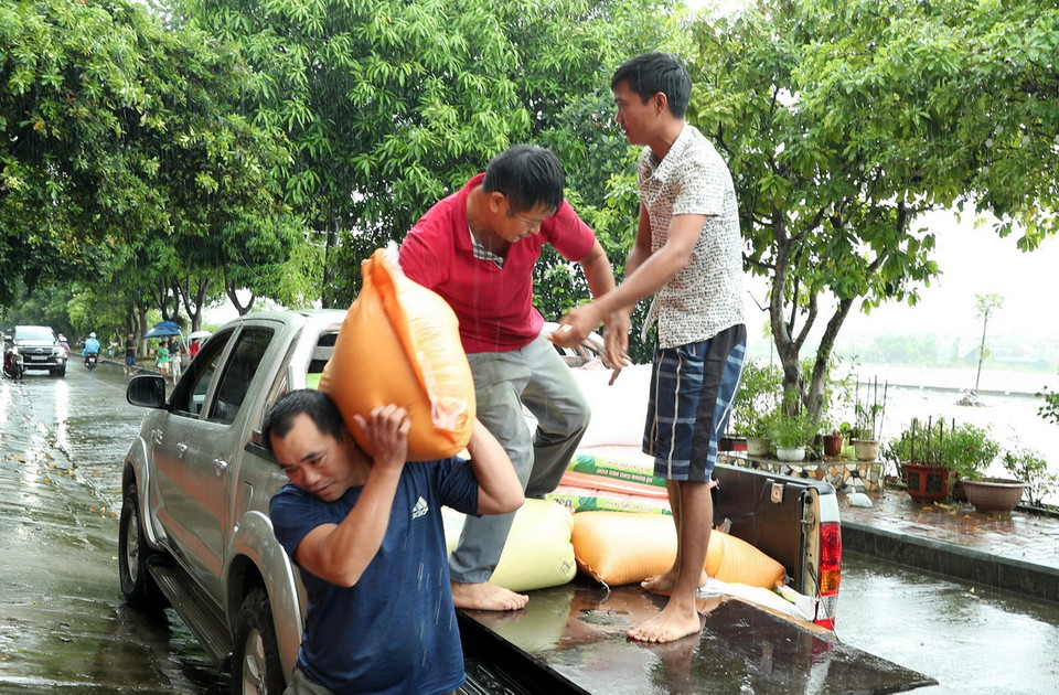 Người dân thành phố Lào Cai di chuyển lương thực đến nơi an toàn. (Ảnh: Quốc Khánh /TTXVN)