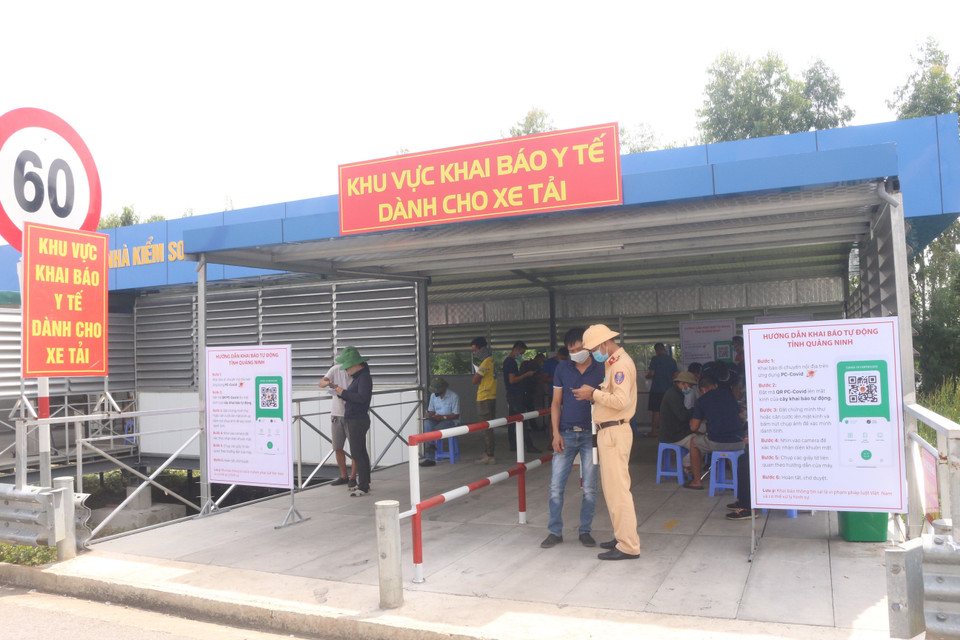 Lực lượng Cảnh sát giao thông hướng dẫn các lái xe khai báo tại khu vực khai báo y tế tự động. (Ảnh: Thanh Vân/TTXVN)