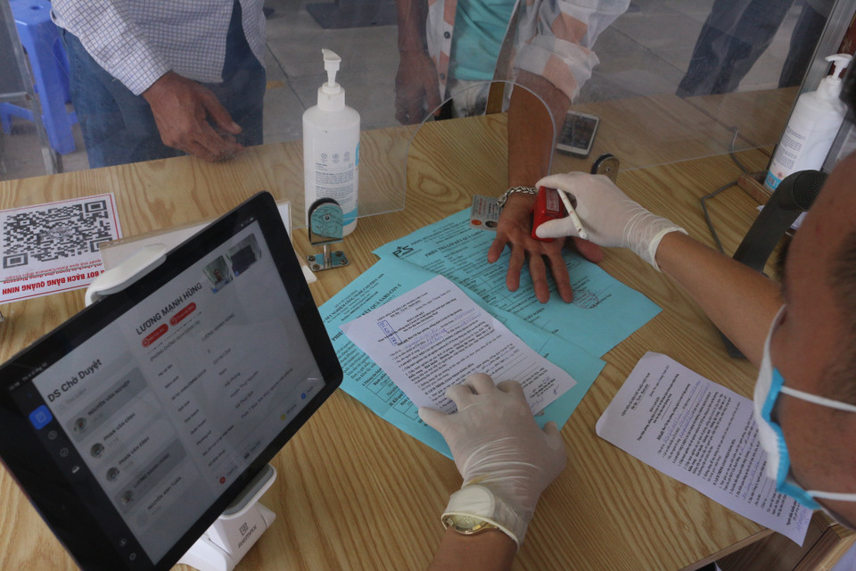 Sau khi cập nhật các thông tin lên hệ thống tự động, người dân được nhân viên kiểm soát duyệt đi qua chốt. (Ảnh: Thanh Vân/TTXVN)