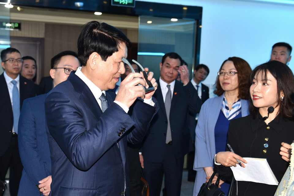 Đồng chí Lương Cường trải nghiệm một số sản phẩm của Công ty kỹ thuật cao LL Vision. (Ảnh: Thành Dương/TTXVN)