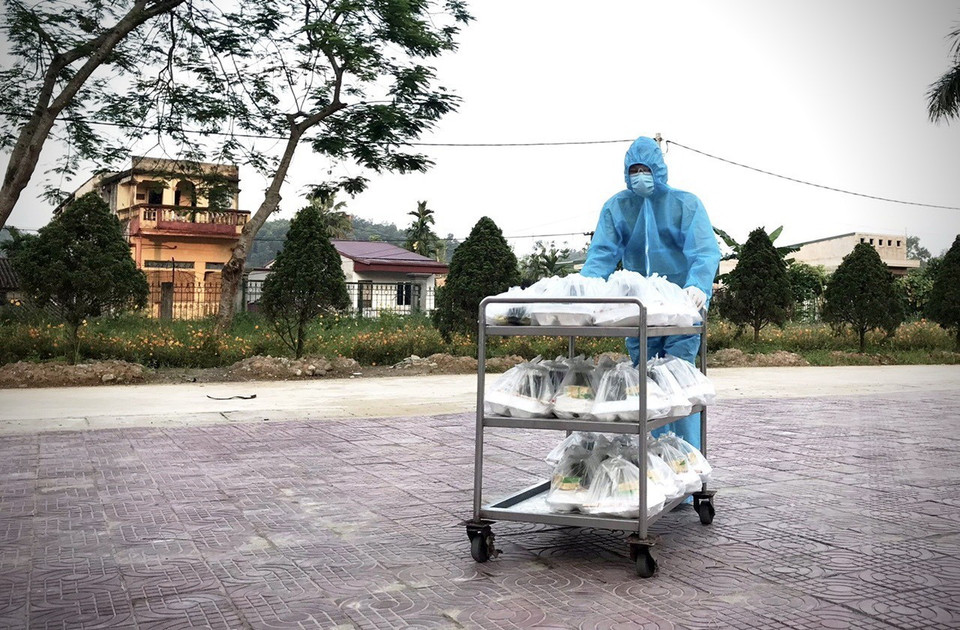 Nhân viên vận chuyển các suất ăn cho những người trong khu cách ly tập trung số 7. (Ảnh: Tuấn Anh-Hoàng Long/TTXVN phát)