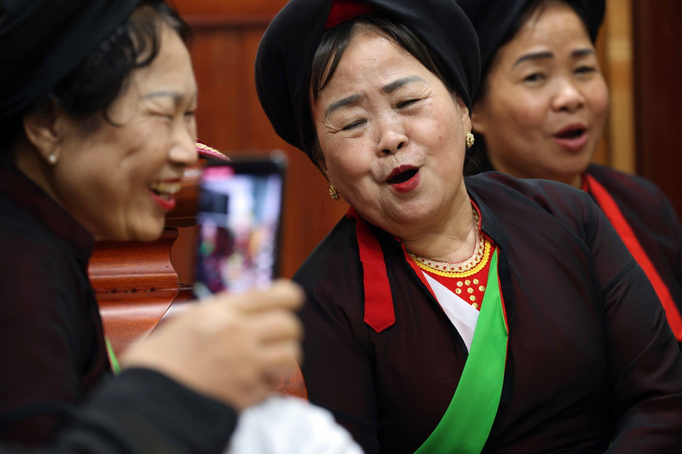 Nghệ nhân ưu tú Nguyễn Thị Ly (giữa) cùng các liền chị đối đáp trong đêm hát canh. (Ảnh: Nhật Anh/TTXVN)