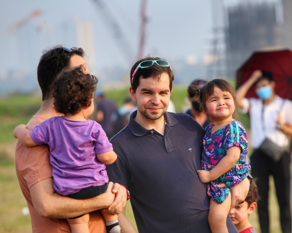 Nhiều du khách quốc tế đưa cả con nhỏ đến khu vườn nhãn Long Biên ven sông Hồng. (Ảnh: Tuấn Đức/TTXVN)