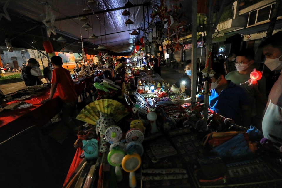 Chợ đêm trên phố Hàng Dầu tắt điện và sử dụng ánh sáng của điện thoại. (Ảnh: Tuấn Đức/TTXVN)