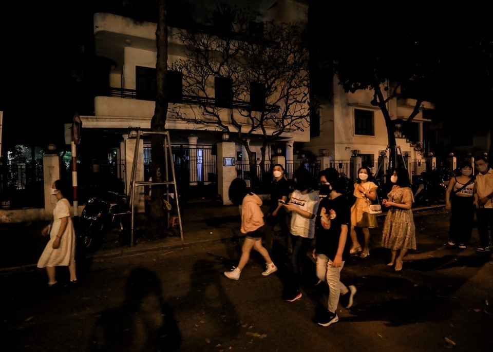 Người dân đi bộ trong ánh sáng lờ mờ ở Hồ Gươm. (Ảnh: Tuấn Đức/TTXVN)