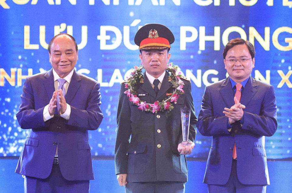 Chủ tịch nước Nguyễn Xuân Phúc và Bí thư thứ nhất Trung ương Đoàn Nguyễn Anh Tuấn trao biểu trưng tuyên dương các Gương mặt trẻ Việt Nam tiêu biểu năm 2021. (Ảnh: Thống Nhất/TTXVN)