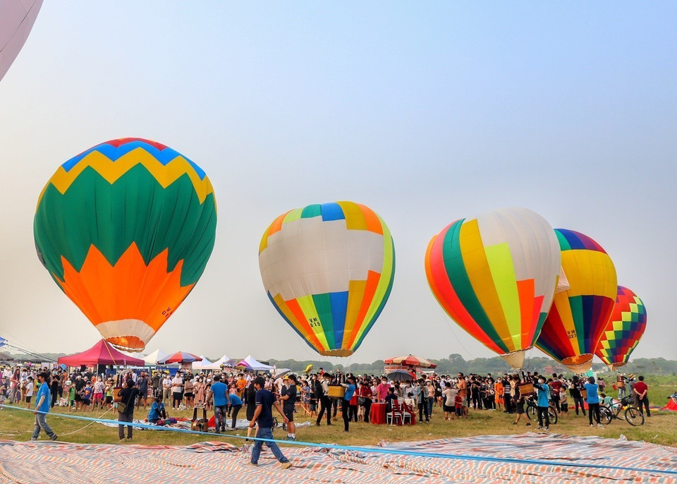 Nhiều người dân Thủ đô đổ xô về khu vườn nhãn Long Biên ven sông Hồng, dưới chân cầu Vĩnh Tuy, quận Long Biên để nghỉ dưỡng, cắm trại cuối tuần. (Ảnh: Tuấn Đức/TTXVN)
