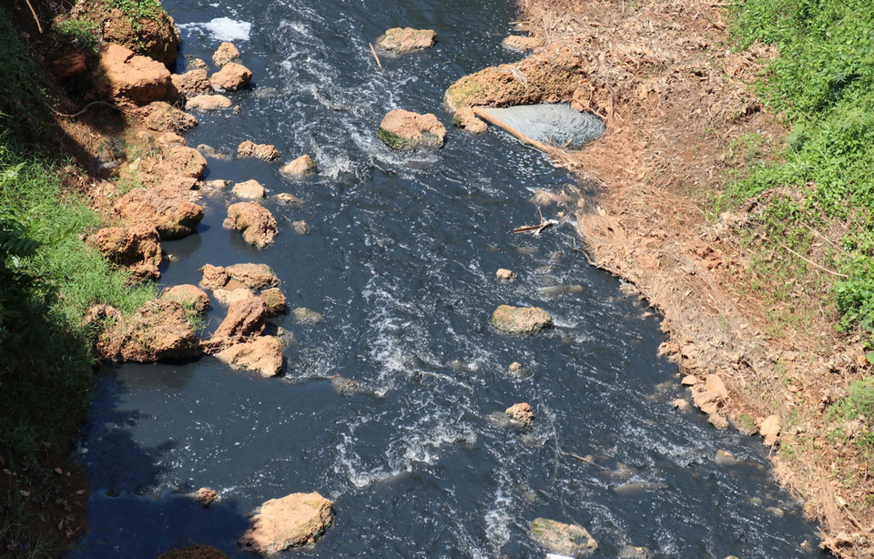 Nước Suối Tân chuyển thành màu đen như mực. (Ảnh: Đậu Tất Thành/TTXVN)