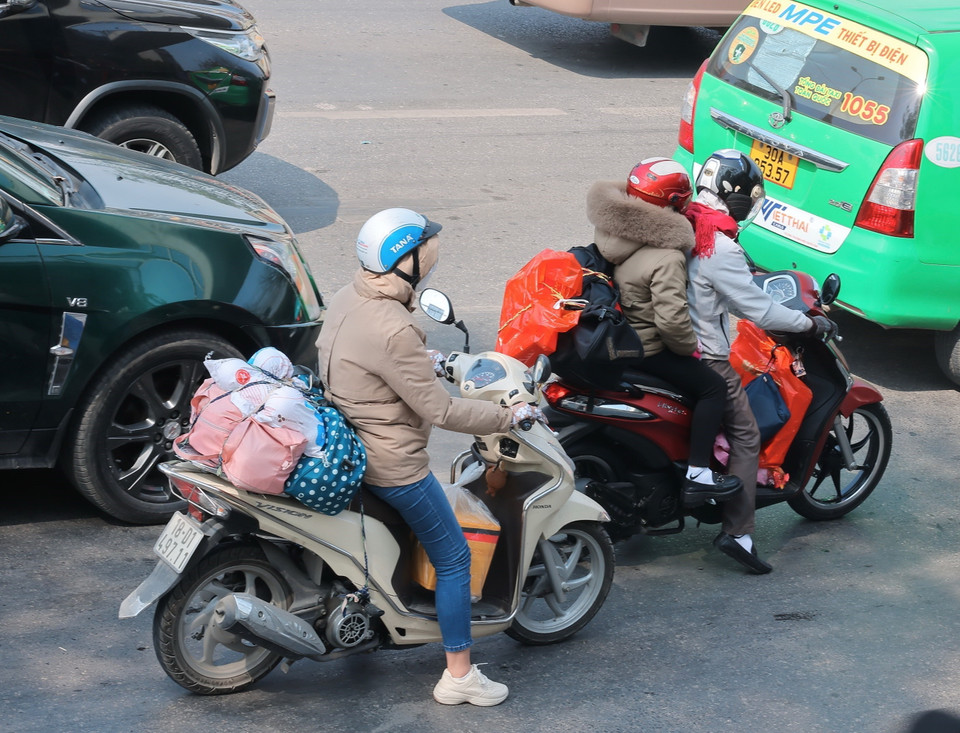 Người dân với hành lý được chằng buộc cẩn thận di chuyển từ phía Nam về hướng trung tâm thành phố. (Ảnh: Hoàng Hiếu/TTXVN)