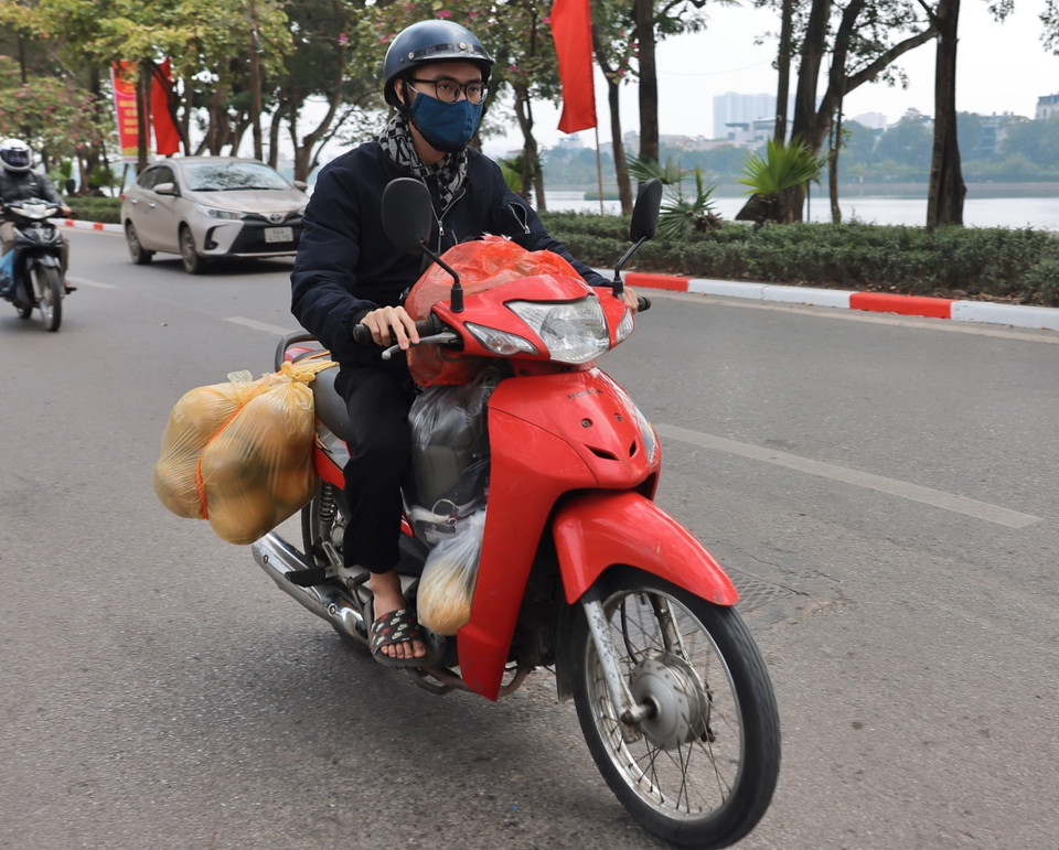 Người dân với đồ đạc, quà quê từ hướng QL1A di chuyển vào khu vực Linh Đàm. (Ảnh: Hoàng Hiếu/TTXVN)