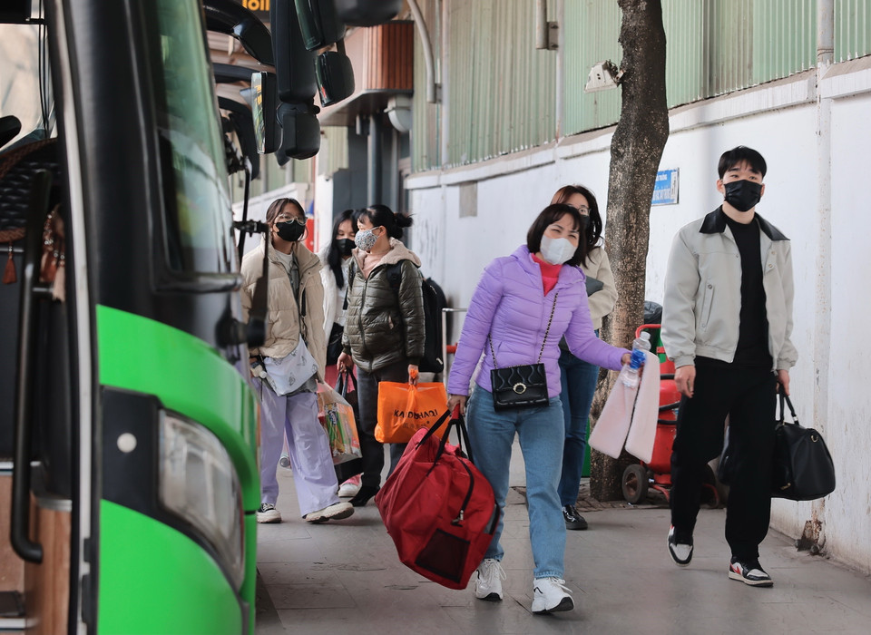 Hành khách xuống xe tại Bến xe Nước Ngầm trưa 13/2. (Ảnh: Hoàng Hiếu/TTXVN)