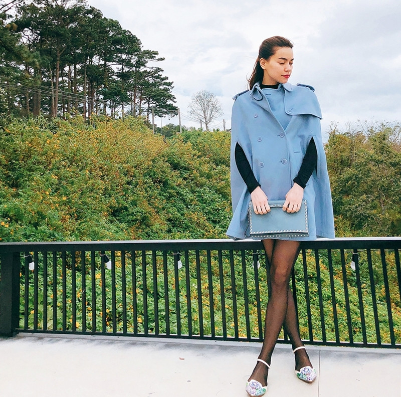 Áo khoác còn được Hồ Ngọc Hà kết hợp khéo léo theo công thức giấu quần. Với thiết kế áo cape xanh phấn, ''nữ hoàng giải trí'' khoe đôi chân nuột nà, thon gọn. Để nhấn nhá vẻ điệu đà, người đẹp còn chọn giày Mary Jane, điểm trang clutch nạm đinh tiệp màu áo.
